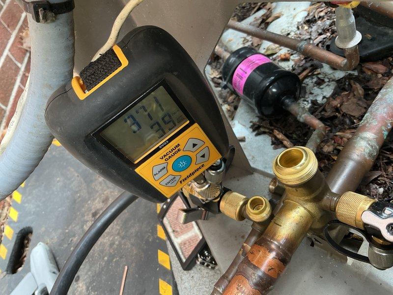 Returned to property to repair refrigerant leak in lineset at connection point between outdoor condenser unit and indoor evaporator coil. System had been isolated and pressurized with nitrogen for leak detection during previous visit. Upon arrival, performed vacuum test using digital micron gauge to verify system integrity after allowing nitrogen to dissipate. Replaced damaged suction line 90-degree elbow fitting at penetration point where lineset transitions from exterior to interior. Brazed new copper fitting into place, pressure tested repair with nitrogen to 350 PSI, and held for 15 minutes with no pressure drop detected. Evacuated system to proper vacuum levels below 500 microns using vacuum pump and digital gauge. Recharged system with appropriate refrigerant per manufacturer specifications. Verified all connections leak-free using electronic leak detector. Restored power to condensing unit and confirmed normal system operation with proper superheat and subcooling readings. Left 