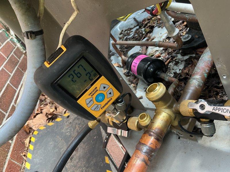 Returned to property to repair refrigerant leak in lineset at connection point between outdoor condenser unit and indoor evaporator coil. System had been isolated and pressurized with nitrogen for leak detection during previous visit. Upon arrival, performed vacuum test using digital micron gauge to verify system integrity after allowing nitrogen to dissipate. Replaced damaged suction line 90-degree elbow fitting at penetration point where lineset transitions from exterior to interior. Brazed new copper fitting into place, pressure tested repair with nitrogen to 350 PSI, and held for 15 minutes with no pressure drop detected. Evacuated system to proper vacuum levels below 500 microns using vacuum pump and digital gauge. Recharged system with appropriate refrigerant per manufacturer specifications. Verified all connections leak-free using electronic leak detector. Restored power to condensing unit and confirmed normal system operation with proper superheat and subcooling readings. Left 