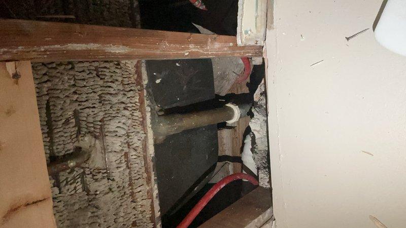 Responded to water leak in kitchen ceiling of 1948-built home. Accessed ceiling cavity above kitchen near bathroom area to locate source of leak first noticed one day prior. Inspection revealed compromised plumbing connection in wall cavity. Removed section of ceiling drywall to expose copper supply lines and drainage system. Identified active leak at corroded pipe joint serving bathroom fixtures above. Shut off water supply to affected line, removed damaged section of piping, and installed new copper pipe segment with proper fittings. Tested all connections under pressure to verify repair integrity and confirm no additional leaks present. Documented existing conditions of kitchen and exposed plumbing infrastructure with photographs for record. Advised monitoring ceiling area for any residual moisture and recommended evaluation of other original plumbing throughout home given age of system.