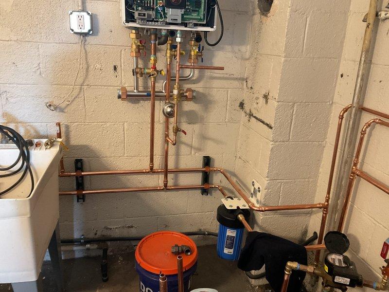 Completed gas line repairs in basement utility area. Inspected and serviced copper gas piping system with multiple vertical and horizontal runs, including brass fittings, valves, and pressure gauges mounted to cinder block walls. Verified integrity of connections and tested system for proper operation and safety compliance.