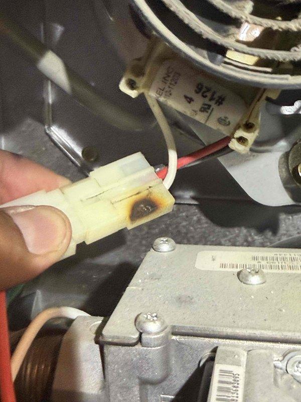 Responded to no heat call on 14-year-old Bryant furnace system. Upon inspection, discovered severely heat-damaged inducer motor connector with evident burn marks and discoloration on the plastic housing. The thermal damage to the electrical connector was causing intermittent or complete loss of power to the inducer motor assembly, preventing proper furnace operation and startup sequence. Documented the failed connector and motor assembly with photographic evidence showing the extent of heat damage and compromised electrical connection. Advised replacement of the inducer motor assembly due to the damaged connector and potential motor degradation from electrical arcing. System age and component condition indicate normal wear failure for equipment in this service life range. Provided recommendations for complete repair to restore heating functionality.