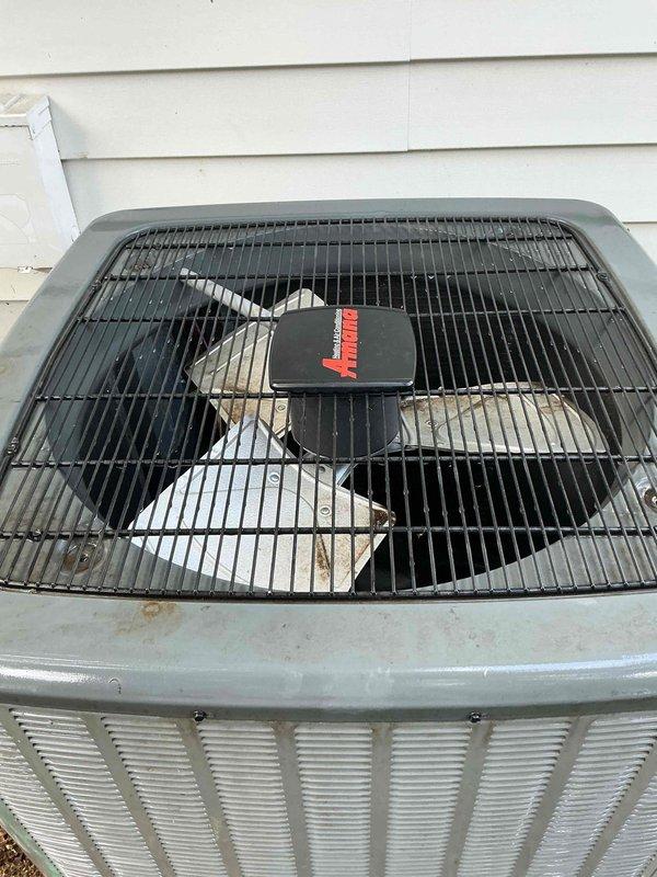 Performed comprehensive tune-up on five-year-old outdoor air conditioning system. Upon arrival, found condenser unit with significant debris accumulation on top grille, including dried leaves, plant material, and organic growth concentrated around protective cage edges and between grille bars. Removed all debris from top grille and fan assembly, cleaned condenser coils and exterior housing, inspected fan blades and motor assembly for proper operation, and verified all ventilation pathways were clear of obstructions. Unit showed normal weathering consistent with age and outdoor exposure. Completed standard maintenance procedures including checking refrigerant levels, testing electrical connections, inspecting capacitor and contactor, measuring amperage draw, and verifying proper airflow through condenser coils. System operational and running within manufacturer specifications upon completion.