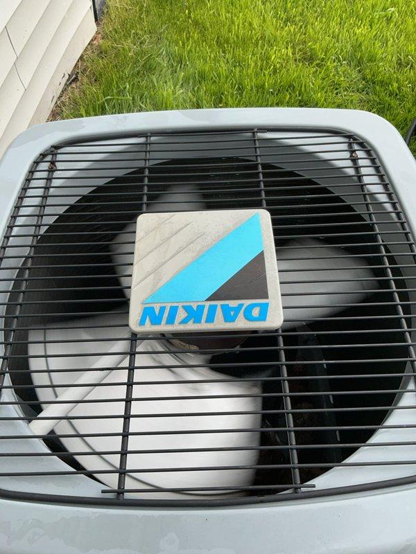 Completed prepaid maintenance inspection on 2018 Daikin air conditioning system with basement evaporator coil. Performed visual inspection of outdoor condenser unit, verified proper fan operation, and documented equipment condition with photos showing unit in good working order with clean exterior housing and unobstructed airflow through protective grille.