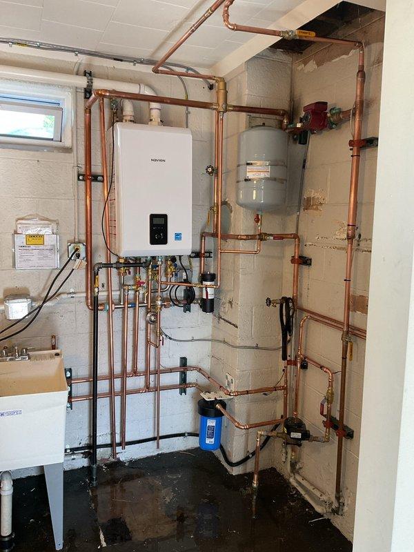 Completed two-day installation of Navien combination boiler system in residential basement mechanical room. Installed wall-mounted combi unit with comprehensive copper piping network, including supply and return lines, expansion tank, pressure relief components, and water filtration system. Routed and secured all piping with proper support brackets, installed necessary valves and fittings, and integrated system with existing plumbing infrastructure. Permit requested and all work performed to code specifications.