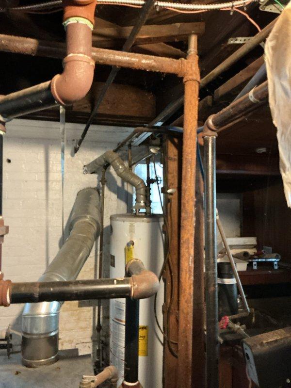 Conducted estimate for steam boiler system located in basement following flooding incident. Inspected 10+ year old boiler equipment and associated plumbing infrastructure, including copper supply lines, expansion tank, and valve assemblies. Assessed condition of piping network showing age-related oxidation and patina buildup. Evaluated water damage impact on mechanical systems and documented existing installation configuration. Equipment currently operational at time of inspection. Provided recommendations for necessary repairs or replacement options based on flood damage assessment and system age.