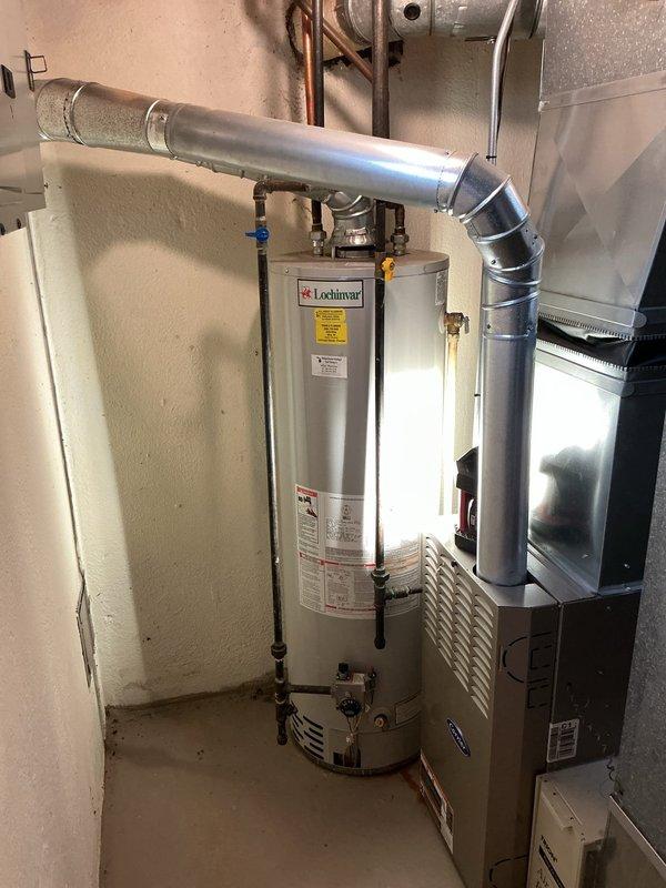Responded to service call for reported leak on 40-gallon water heater. Upon arrival, performed diagnostic inspection of existing Lochinvar tanked water heater unit installed in utility space. Examined all plumbing connections, including copper supply lines, gas connections via black flexible pipes, and associated shutoff valves. Inspected condition of tank, pressure relief valve, drain valve, and all visible piping connections for signs of active leakage or corrosion. Assessed overall system configuration including blue-handled water shutoff valve, yellow gas valve, and PVC venting arrangement. Documented current installation with photographic evidence showing complete plumbing assembly, HVAC integration, and mechanical room layout. Provided homeowner with findings and discussed replacement options for the water heating system.