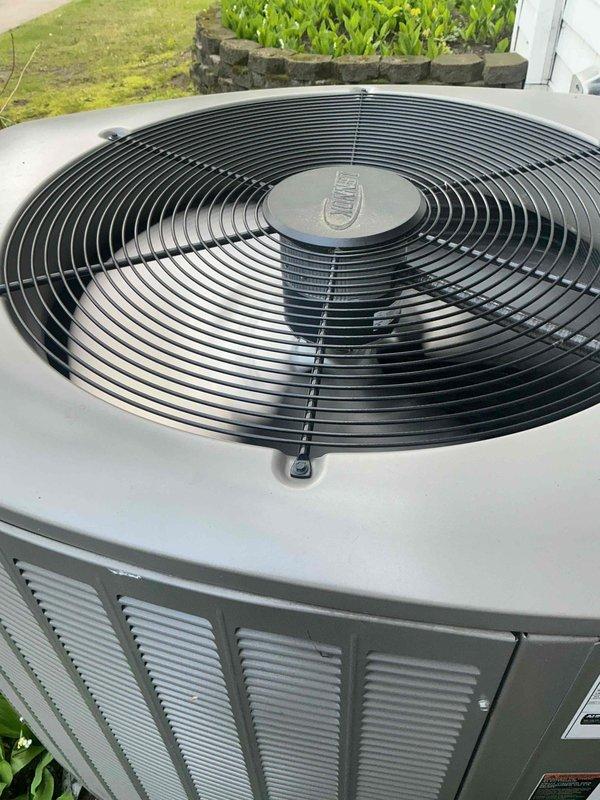 Completed air conditioning inspection and tune-up on one-year-old residential system. Inspected outdoor condenser unit, confirming fan operation, blade integrity, and proper airflow through coil louvers; unit mounted on concrete pad showing normal condition with no visible damage or corrosion. Examined electrical connections at disconnect box, verifying wire terminations, terminal integrity, and proper conductor routing. Air handler located in basement confirmed operational. System operating within normal parameters at time of inspection.