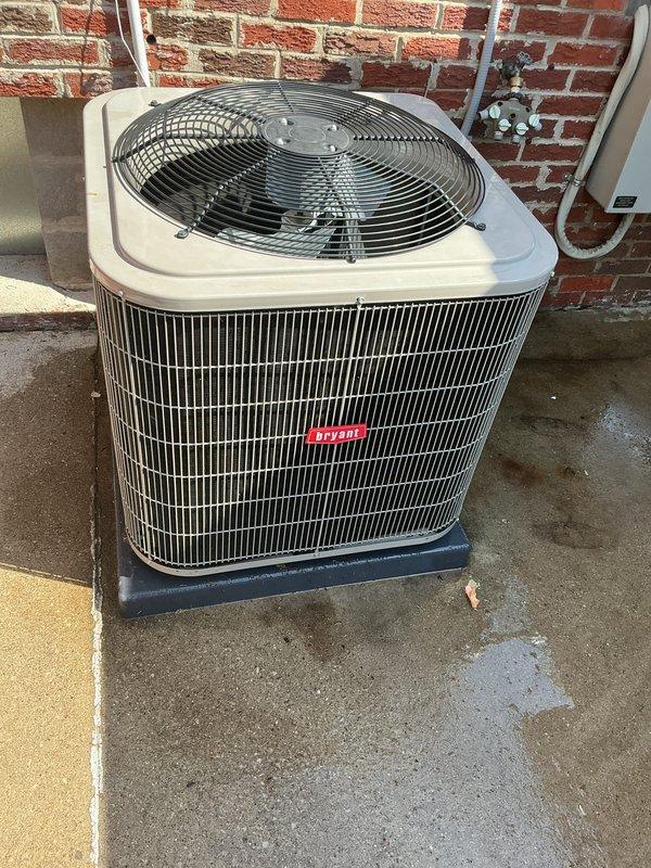 Completed comprehensive Gold AC inspection on Bryant air conditioning system under 10 years old with air handler located in basement. System confirmed operational with outdoor condensing unit properly positioned on concrete pad next to building exterior. Inspected condenser coils, refrigerant lines, electrical disconnect, and fan assembly; all components functioning within normal parameters. Advised customer to maintain clear area around condenser unit, removing any debris or animal waste to ensure proper airflow and system efficiency.