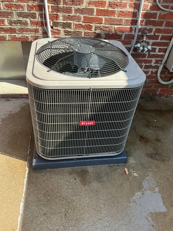 Completed comprehensive Gold AC inspection on Bryant air conditioning system under 10 years old with air handler located in basement. System confirmed operational with outdoor condensing unit properly positioned on concrete pad next to building exterior. Inspected condenser coils, refrigerant lines, electrical disconnect, and fan assembly; all components functioning within normal parameters. Advised customer to maintain clear area around condenser unit, removing any debris or animal waste to ensure proper airflow and system efficiency.