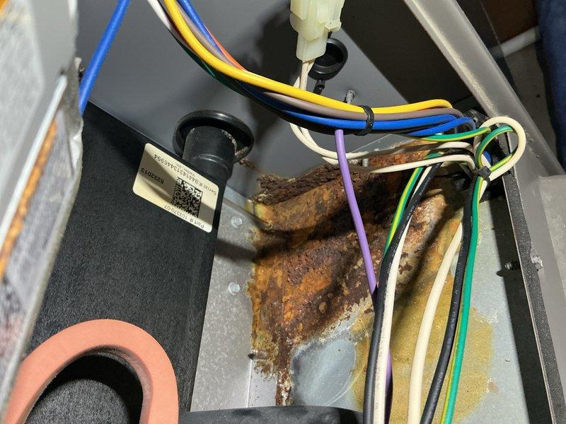 Completed comprehensive tune-up service on 14-year-old furnace and air conditioning system located in basement, along with hot water tank flush service. Performed full system inspection and maintenance on both heating and cooling equipment. During inspection, identified significant rust and corrosion on copper refrigerant line within AC unit, as well as rust present on internal mounting bracket in furnace compartment, indicating potential moisture exposure concerns. Documented all electrical connections, gas valve operation, and circulation pump functionality. All systems tested and confirmed operational at time of service completion.