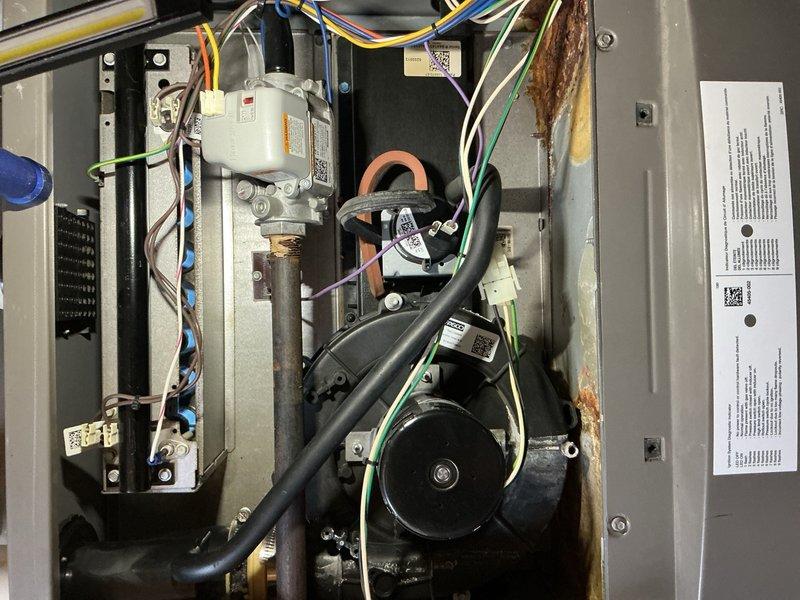 Completed comprehensive tune-up service on 14-year-old furnace and air conditioning system located in basement, along with hot water tank flush service. Performed full system inspection and maintenance on both heating and cooling equipment. During inspection, identified significant rust and corrosion on copper refrigerant line within AC unit, as well as rust present on internal mounting bracket in furnace compartment, indicating potential moisture exposure concerns. Documented all electrical connections, gas valve operation, and circulation pump functionality. All systems tested and confirmed operational at time of service completion.