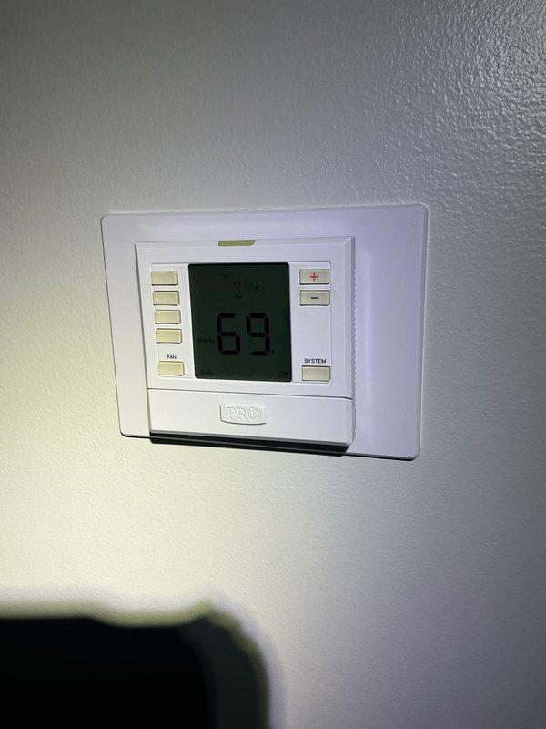 Returned to property to perform leak search and level condenser unit as previously documented. Completed comprehensive Gold AC inspection on multi-unit system consisting of three HVAC systems with two air handlers located in basement and one with refrigerant lines in attic. All equipment is under 10 years old and operational at time of inspection. Verified thermostat functionality showing proper temperature control at 69°F. Conducted thorough system evaluation including refrigerant leak detection, condenser leveling, and performance verification across all three units. All systems functioning properly with no immediate issues identified.