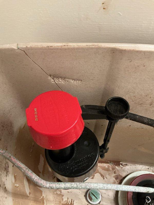 Responded to residential plumbing service call addressing multiple fixtures in 20-year-old home. Inspected basement toilet with reported float/parts malfunction; removed tank lid and assessed fill valve assembly, flapper mechanism, and internal components showing mineral deposits and wear consistent with age. Photographed tank interior documenting condition of fill valve with red adjustment cap, flush valve assembly, and water supply connections. Identified staining and sediment buildup throughout tank indicating hard water exposure. Evaluated upstairs bathroom sink with intermittent dripping issue for minor repair requirements. Assessed outdoor hose faucet where hose connection was stuck and required specialized removal tool for service. Provided technical recommendations for necessary repairs and component replacements based on inspection findings.