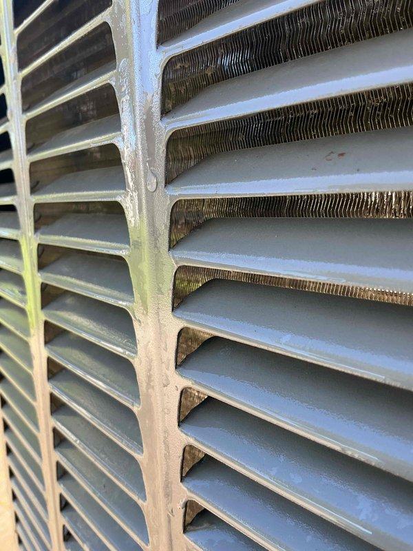 Completed comprehensive Gold AC inspection on one-year-old system with air handler located in basement. Performed full system evaluation including condenser unit examination, evaporator coil assessment, and air filter inspection. Inspected heat exchanger fins and condenser coil assembly, noting minor discoloration on aluminum fins and some oxidation on corrugated components typical of normal operation. Examined ventilation grate and filter medium, observing light dust accumulation and minor debris between slats consistent with regular use. Verified system operational status and documented equipment condition through photographic documentation. Advised customer on importance of maintaining clear area around condenser unit, free from debris and animal waste to ensure optimal system performance and longevity.