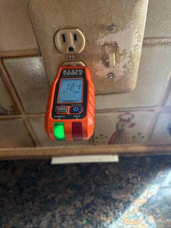 Responded to service call for non-functioning garbage disposal and problematic switch. Performed electrical diagnostics and testing of kitchen outlet circuits using digital voltage tester, confirming proper 124 VAC power supply and correct wiring at receptacle locations. Inspected switch controlling garbage disposal unit and associated electrical connections in kitchen area with decorative tile backsplash. Verified circuit integrity and proper grounding throughout affected areas.