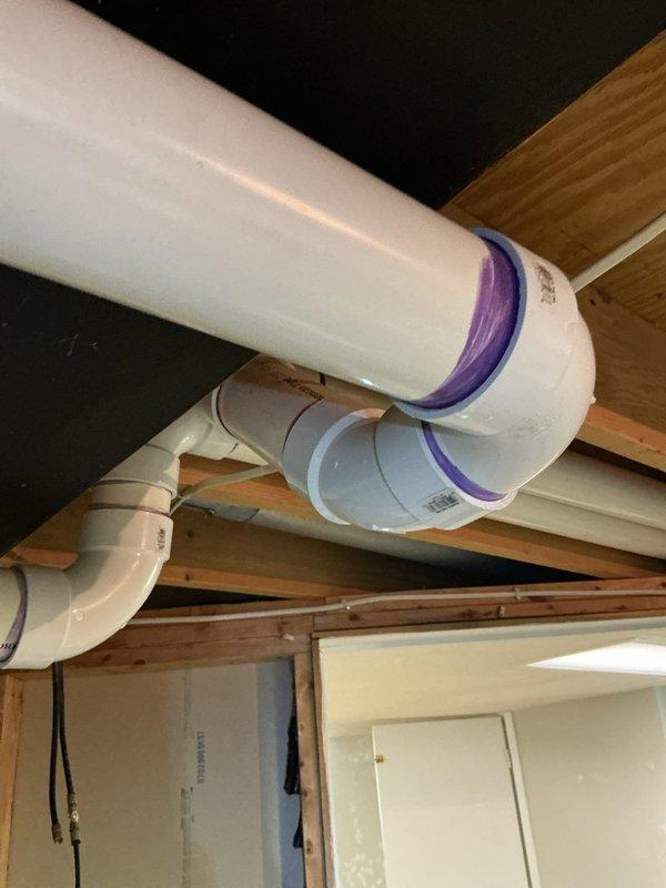 Responded to service call for leaking exhaust vent on 9-year-old furnace located in basement. Upon inspection, identified water leak at furnace exhaust PVC vent piping connections. Inspected all visible PVC vent pipe runs, joints, and fittings throughout the ceiling joist system to locate source of moisture intrusion. Verified proper pipe slope and drainage configuration on condensate and exhaust vent lines, noting purple-primed joints and coextruded cellular core PVC piping installation. Addressed leak at vent connection point, ensuring all exhaust vent fittings were properly sealed and secured to prevent future water infiltration. System tested and confirmed no active leaking upon completion.