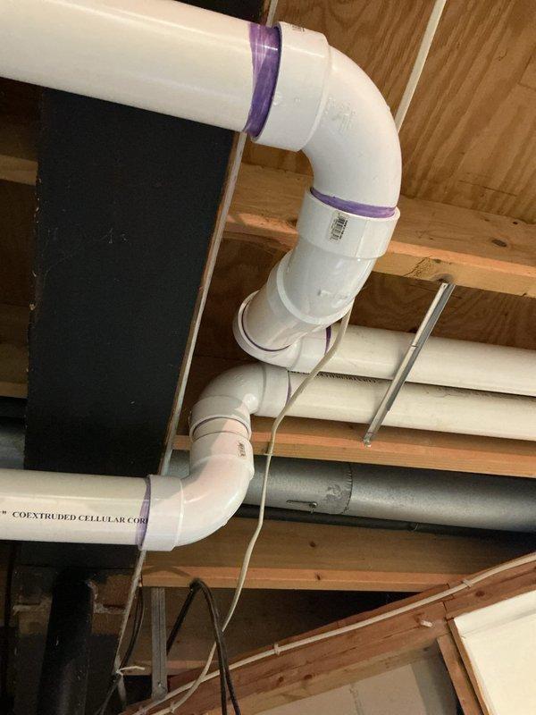Responded to service call for leaking exhaust vent on 9-year-old furnace located in basement. Upon inspection, identified water leak at furnace exhaust PVC vent piping connections. Inspected all visible PVC vent pipe runs, joints, and fittings throughout the ceiling joist system to locate source of moisture intrusion. Verified proper pipe slope and drainage configuration on condensate and exhaust vent lines, noting purple-primed joints and coextruded cellular core PVC piping installation. Addressed leak at vent connection point, ensuring all exhaust vent fittings were properly sealed and secured to prevent future water infiltration. System tested and confirmed no active leaking upon completion.