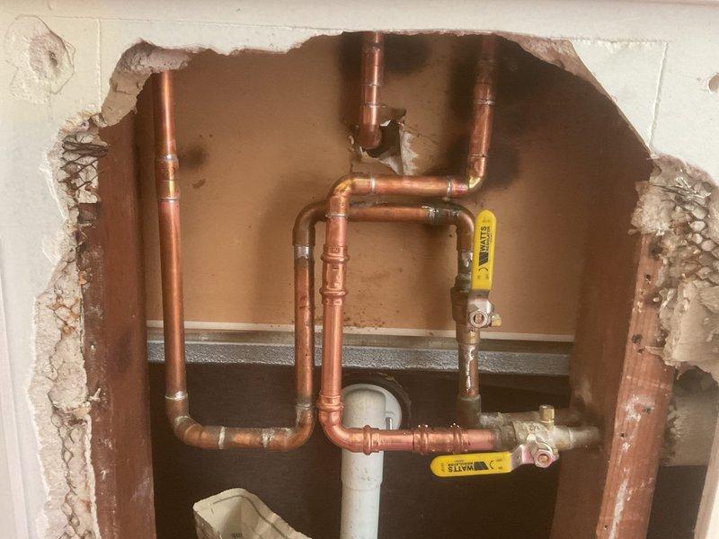 Performed plumbing repair requiring wall demolition to access concealed piping system. Exposed and serviced multiple copper supply lines with gas shut-off valves and associated PVC drainage components. Special order parts required for completion; customer instructed to call 313-930-7474 and 586-925-2555 for ordering and scheduling.