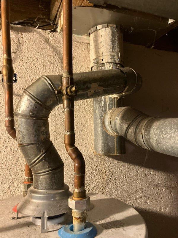 Conducted comprehensive evaluation of existing 25-year-old residential HVAC system for full replacement estimate. Assessed gas furnace located in basement, currently operational, and outdoor air conditioning condenser unit with distinctive circular fan configuration positioned on concrete pad with decorative rock landscaping against exterior brick wall. Documented existing system components including ductwork connections, copper refrigerant lines, and electrical service. Photographed condenser unit showing age-related wear and basement furnace installation with metal supply duct transitions and piping connections. Provided customer with complete system replacement options for both heating and cooling equipment based on current system age and configuration.