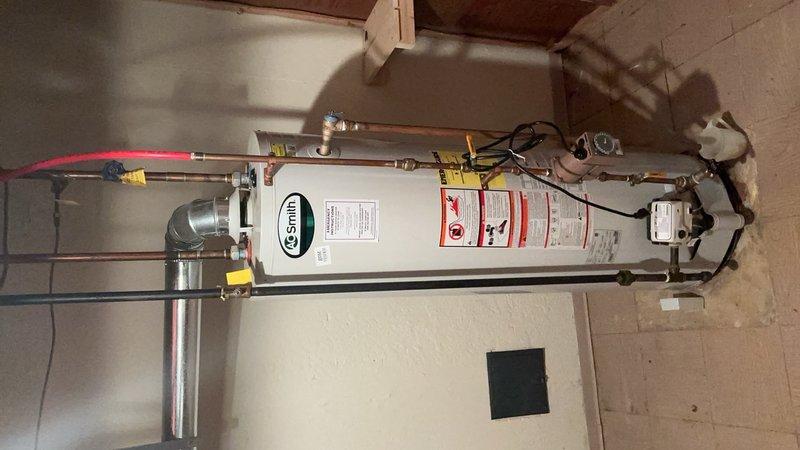 Installed a 40-gallon A.O. Smith electric water heater in the utility room with copper piping connections, brass fittings, and yellow-handled shut-off valves at the top of the unit. Customer provided their own drain pan for the installation, and all electrical connections were completed to code with proper junction box mounting.