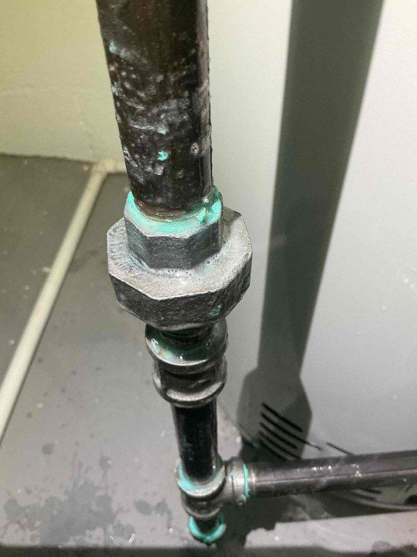 Responded to callback for reported gas leak on recently installed Bradford White 50-gallon natural gas water heater (Model RG250G6N, 40,000 BTU input). Upon inspection, discovered severe corrosion on gas supply piping connections with characteristic blue-green copper corrosion deposits (verdigris) visible on threaded unions and fittings. Black pipe coating deteriorated with extensive pitting and oxidation present on vertical and horizontal gas line sections. Documented corroded connections and compromised pipe integrity with photographic evidence. System requires immediate gas line replacement due to safety concerns and potential leak points at deteriorated fittings.