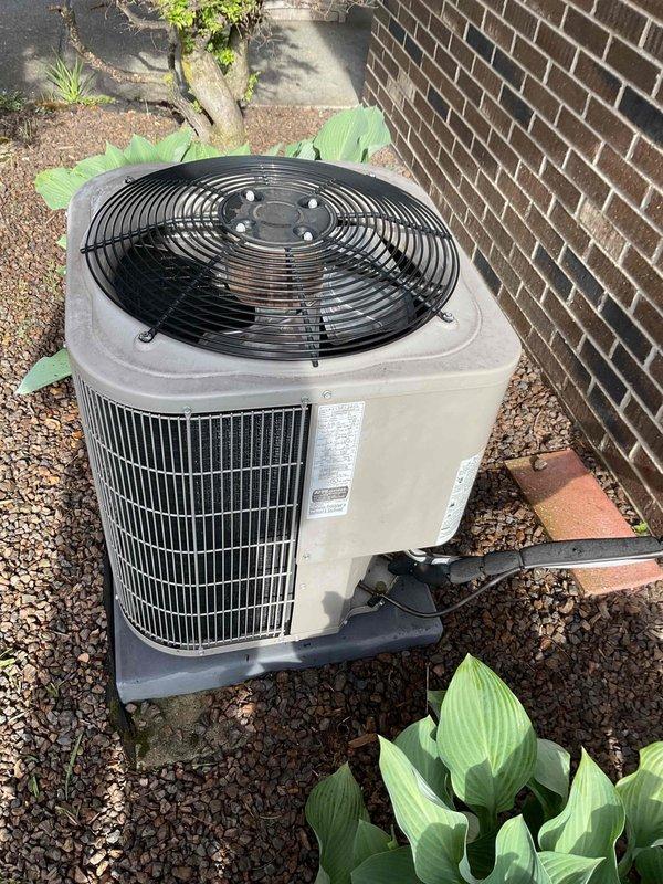 Completed comprehensive Gold AC inspection on a 10-year-old residential air conditioning system. Unit confirmed operational at time of service. Performed thorough examination of outdoor condenser unit positioned against building exterior, noting standard wear consistent with age. Inspected electrical components including capacitor, wiring connections, and terminal blocks within unit compartment. All color-coded wiring and electrical connections verified secure and properly configured. Condenser unit exterior housing and fan grille inspected with no significant damage observed. Unit mounted on appropriate base pad with proper clearance from landscaping. Refrigerant lines and electrical conduit connections checked for integrity. System components photographed for service records.