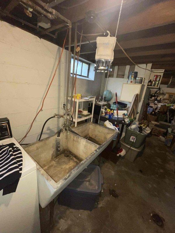 Conducted comprehensive site assessment for complete HVAC system replacement in basement utility area of small residential property (0-1500 sq ft). Evaluated existing heating and cooling equipment configuration, including natural gas furnace and air conditioning components, documented current ductwork layout and support structures, assessed utility connections and clearance requirements for new equipment installation. Photographed existing conditions including equipment location, utility sink proximity, ceiling-mounted components, ductwork pathways, and available workspace to develop replacement specifications and installation plan for new heating and cooling system.