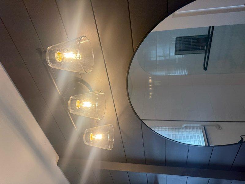 Responded to service call for non-functioning wall-mounted light fixture and GFCI outlet replacement. Diagnosed power issue at wall fixture and restored electrical service. Replaced multiple GFCI outlets with properly grounded units to meet current electrical code requirements. Verified all circuits functioning correctly, tested ground fault protection on new outlets, and confirmed three-fixture pendant lighting system operational in bathroom area. All work completed to code specifications with proper grounding throughout.