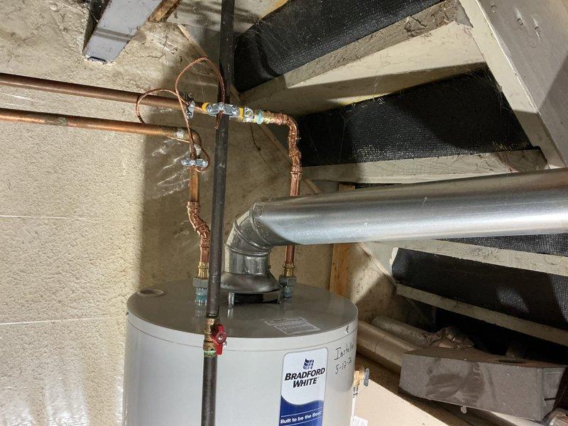 Completed installation of a 40-gallon Bradford White residential water heater in basement utility area. Established all water supply connections using copper piping with soldered joints, installed pressure relief valve with proper discharge piping, and connected metallic vent pipe for exhaust. All plumbing connections were tested and verified leak-free, unit was filled and operational upon completion.