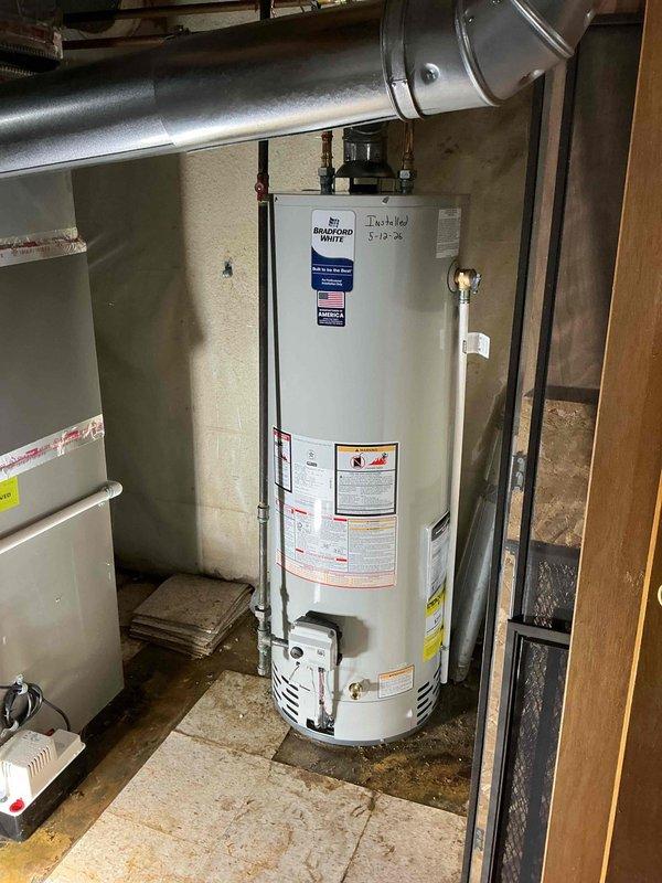 Completed installation of a 40-gallon Bradford White residential water heater in basement utility area. Established all water supply connections using copper piping with soldered joints, installed pressure relief valve with proper discharge piping, and connected metallic vent pipe for exhaust. All plumbing connections were tested and verified leak-free, unit was filled and operational upon completion.