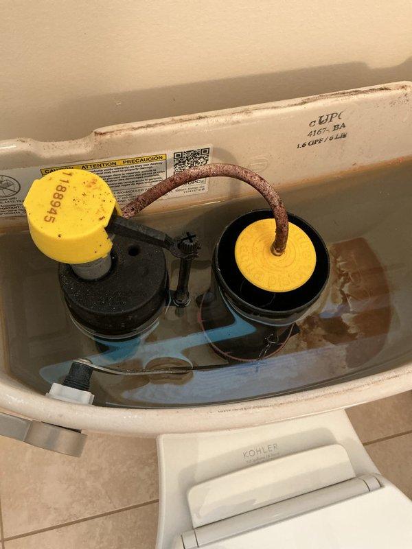 Responded to service call for toilet with flushing and slow fill issues. Upon inspection, identified malfunctioning fill valve with yellow cap and compromised flapper mechanism in Kohler toilet tank. Adjusted flush valve assembly, tested flapper seal, and verified proper chain tension on flush handle mechanism. Confirmed water supply line connection at wall-mounted shut-off valve was secure and functioning correctly. Completed operational testing to ensure proper flush cycle and tank refill rate restored to normal performance.