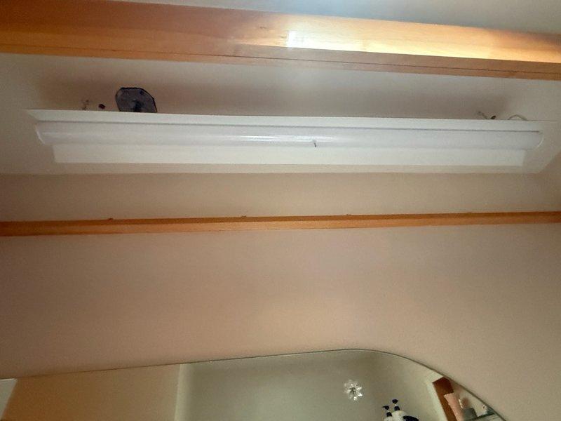 Completed installation of fluorescent light fixture in utility area ceiling space. Mounted fixture to junction box with proper securing hardware and verified electrical connections. Installed diffuser cover and tested operation to ensure proper illumination. All work performed to code specifications with clean professional finish.