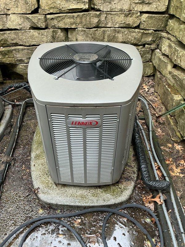Completed comprehensive Gold AC inspection on 1-year-old Lennox outdoor condensing unit located at basement level. Performed thorough evaluation of condenser coils, refrigerant lines, electrical connections, and fan operation. Inspected thermostat functionality, humidifier operation, and hot water tank as part of complete system assessment. Unit found in excellent condition with proper airflow through louvers, secure refrigerant line connections, and clean condenser coils. Verified all components operating within manufacturer specifications with no deficiencies noted.