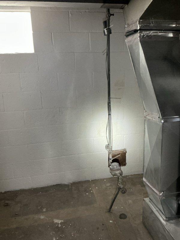 Conducted on-site plumbing assessment in residential basement utility area to provide free estimate for discussed plumbing work. Documented existing conditions including water heater installation, exposed piping systems, HVAC ductwork, and concrete block foundation walls to determine scope of required plumbing modifications and fixture installations.
