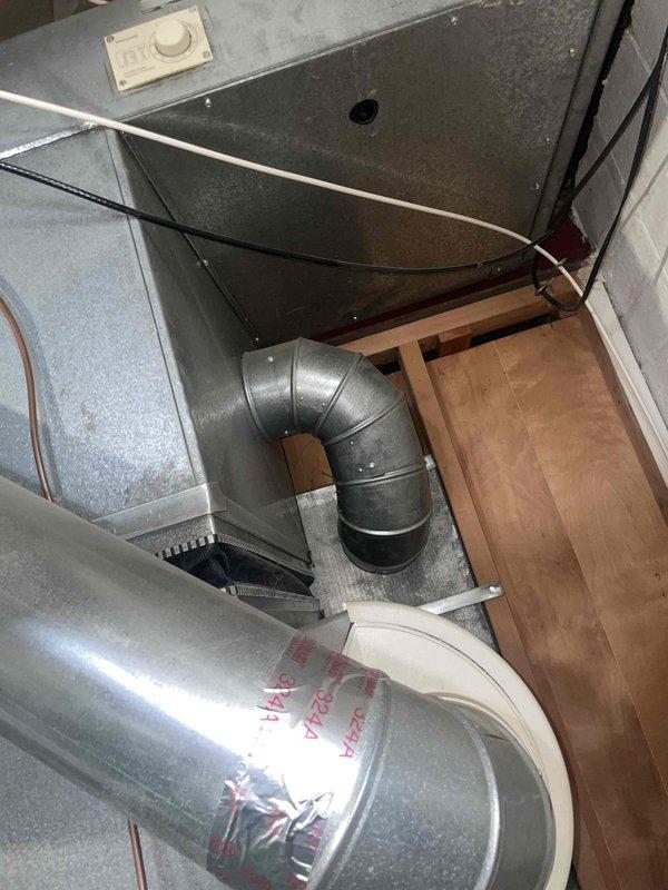 Conducted comprehensive HVAC replacement estimate for 1997 residential system with R22 refrigerant air conditioning unit and furnace. Assessed existing equipment located in basement, noting air conditioner is operational but low on refrigerant. Recommended full system replacement including both air conditioning unit and furnace to ensure optimal efficiency and compatibility, as replacing only the AC unit would result in mismatched components with the aging furnace. Documented current ductwork configuration including galvanized metal supply ducts, flexible insulated ductwork connections, and 90-degree elbow joints throughout the system. Photographed existing installation showing air handler assembly, control devices, and utility space layout to support replacement specifications. Advised that condenser area requires clearing of debris and animal waste prior to new equipment installation. Confirmed basement air handler location suitable for replacement equipment.