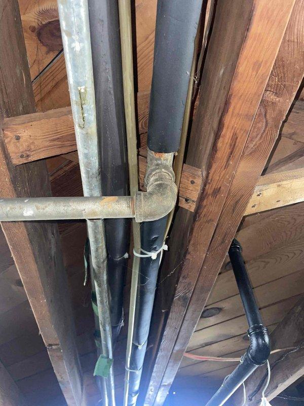 Conducted comprehensive HVAC replacement estimate for 1997 residential system with R22 refrigerant air conditioning unit and furnace. Assessed existing equipment located in basement, noting air conditioner is operational but low on refrigerant. Recommended full system replacement including both air conditioning unit and furnace to ensure optimal efficiency and compatibility, as replacing only the AC unit would result in mismatched components with the aging furnace. Documented current ductwork configuration including galvanized metal supply ducts, flexible insulated ductwork connections, and 90-degree elbow joints throughout the system. Photographed existing installation showing air handler assembly, control devices, and utility space layout to support replacement specifications. Advised that condenser area requires clearing of debris and animal waste prior to new equipment installation. Confirmed basement air handler location suitable for replacement equipment.