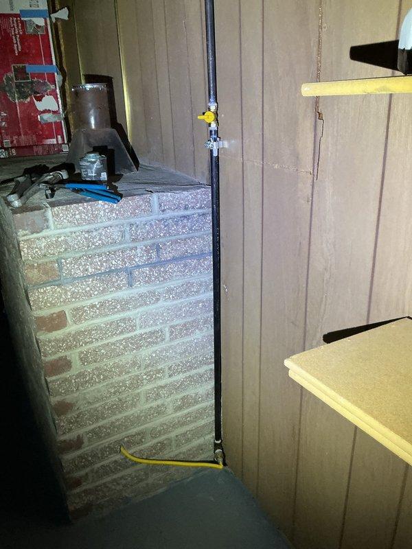 Responded to service call for gas line capping in residential basement. Located existing black iron gas supply line with yellow shut-off valve in utility area near exposed brick wall. Successfully capped off the gas line per customer request to ensure safe disconnection of unused gas supply. Verified proper shut-off valve operation and confirmed no active gas flow to the terminated line. Installation completed in accordance with local gas fitting codes and safety standards.