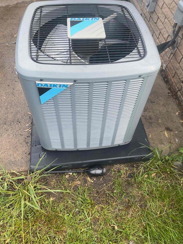 Completed comprehensive Gold Plan AC inspection on residential Daikin condensing unit. Performed full system evaluation including visual inspection of outdoor condenser unit, verified proper operation of fan assembly, checked electrical connections, inspected refrigerant lines and conduit, and assessed overall equipment condition. Unit found to be operating within normal parameters with no deficiencies noted; all components including protective grille, housing, and mounting pad in satisfactory condition with no visible damage or wear requiring immediate attention.