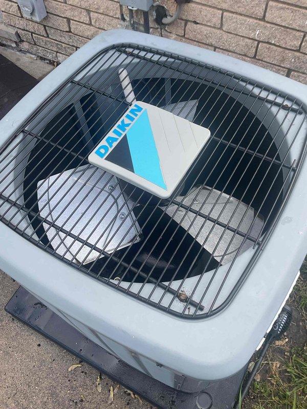 Completed comprehensive Gold Plan AC inspection on residential Daikin condensing unit. Performed full system evaluation including visual inspection of outdoor condenser unit, verified proper operation of fan assembly, checked electrical connections, inspected refrigerant lines and conduit, and assessed overall equipment condition. Unit found to be operating within normal parameters with no deficiencies noted; all components including protective grille, housing, and mounting pad in satisfactory condition with no visible damage or wear requiring immediate attention.