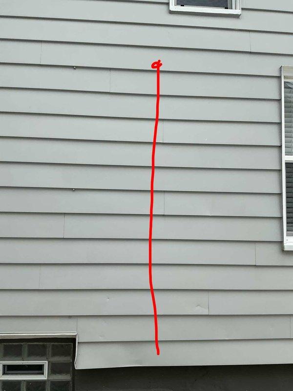 Conducted site assessment for mini split installation in living room and primary bedroom of residence currently served by 21-year-old boiler with no existing cooling system. Evaluated exterior mounting locations, photographed potential condenser placement areas and existing electrical infrastructure including red conduit routing on exterior wall. Documented site conditions including foundation access points, siding configuration, and clearance requirements for outdoor unit installation to prepare comprehensive estimate for dual-zone ductless heat pump system.