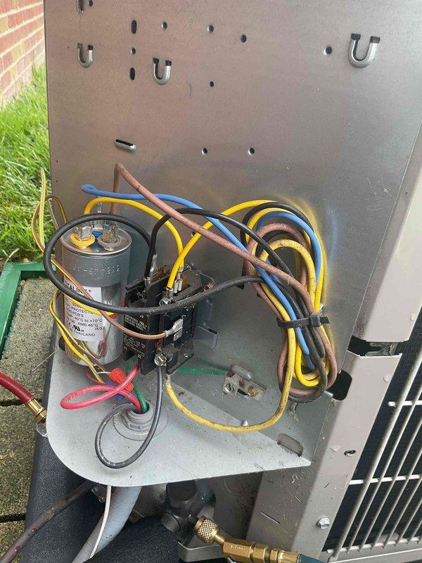 Completed comprehensive Gold AC inspection on 7-year-old Bryant air conditioning system with air handler located in basement. Performed thorough examination of outdoor condenser unit, verifying proper operation of compressor, capacitor, and electrical connections. Inspected wiring configuration including multiple conductor connections, refrigerant line fittings, and condenser coil condition. Unit found to be in operational status with all components functioning within normal parameters. Documented equipment condition through photographic records showing clean coil fins, secure electrical connections, and proper installation on concrete pad. System confirmed operational and ready for continued service.
