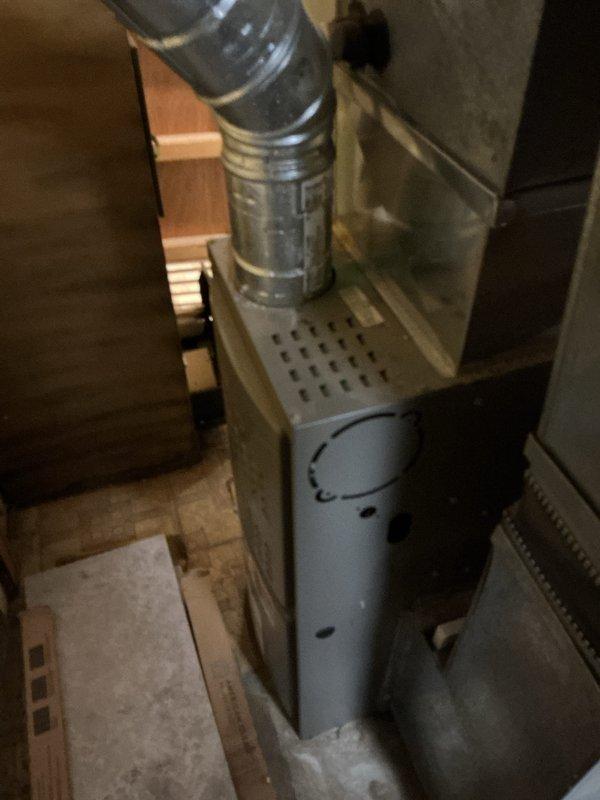 Provided estimate for complete HVAC system replacement in basement location. Existing air conditioning unit non-operational, with equipment age exceeding 10 years showing significant wear and dust accumulation. System assessment included evaluation of cylindrical furnace/air handler with natural gas fuel source, existing ductwork configuration including flexible metallic ducting, and overall installation conditions in confined basement space with exposed framing.