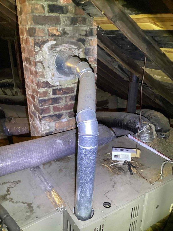 Provided comprehensive estimate for complete HVAC system replacement in attic installation, including air conditioning unit and natural gas furnace, both exceeding 15 years of age. Assessed existing equipment configuration, ductwork connections, and attic space conditions including clearances around brick chimney structure and flue pipe routing. Documented current system layout with flexible ductwork distribution, evaluated structural platform support, and identified replacement requirements for aging but currently operational heating and cooling equipment.