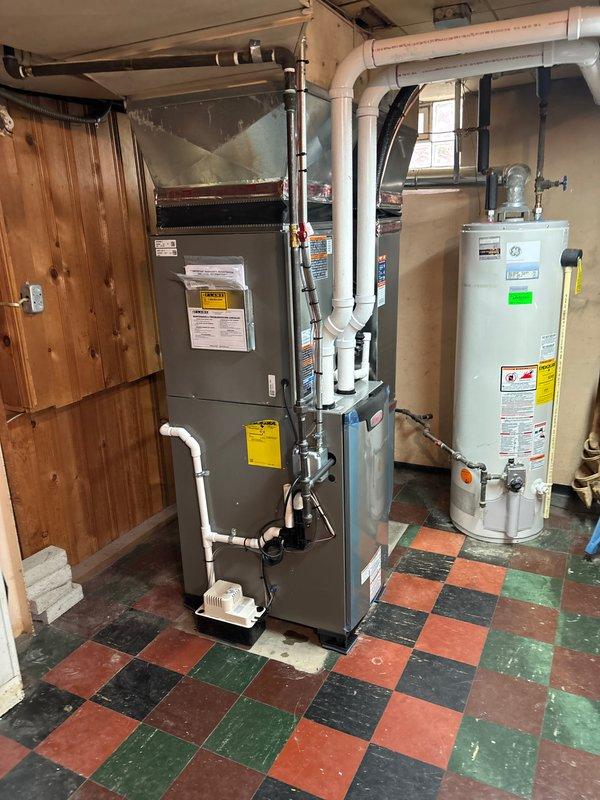 Completed full HVAC system installation including 70,000 BTU furnace with evaporator coil, 2.5-ton air conditioning unit, programmable thermostat, and humidifier. Installed condensate pump with PVC drainage piping to handle system condensate removal. Reconnected existing electrical service and completed all mechanical, electrical, and furnace permits as required. System registered with AHRI certificate 215663829 and qualifies for utility rebate program.