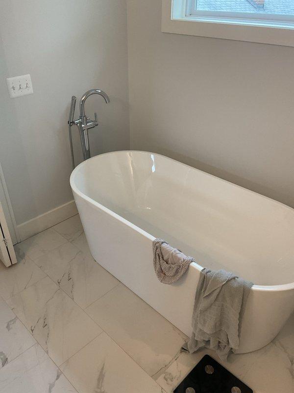 Responded to a clogged drain call in the master bathroom. Upon arrival, inspected the modern bathroom featuring a freestanding tub with floor-mounted fixtures and an adjacent walk-in shower with marble-look tile walls and hexagonal mosaic floor tile. Assessed the drainage system and successfully cleared the obstruction from the master bathroom drain, restoring proper water flow and drainage function.