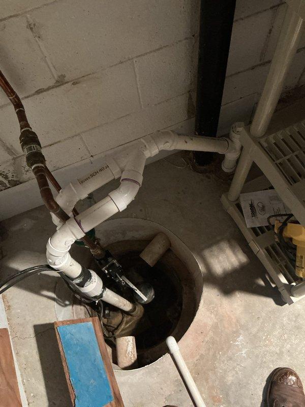 Responded to service call for sump pump evaluation and potential replacement in residential basement utility area. Upon arrival, performed comprehensive inspection of existing sump pump system, basin, and associated discharge piping. Assessed condition of pump operation, float mechanism, and electrical connections. Evaluated PVC discharge line configuration and backflow prevention components. Documented current system setup including basin condition, pipe connections, and overall plumbing infrastructure. Identified areas requiring attention and provided technical assessment for replacement recommendations. System photographed for reference and quote preparation purposes.