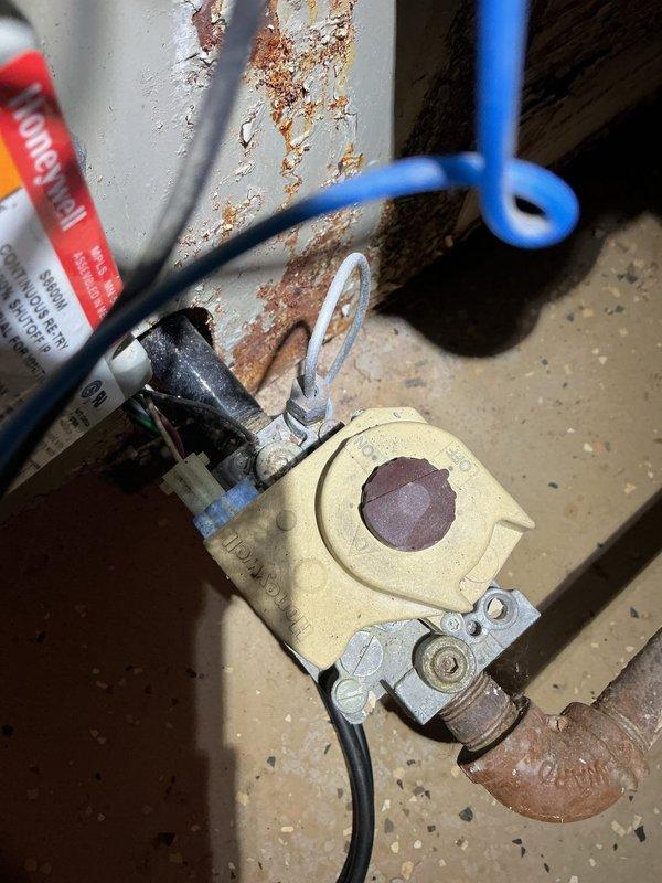 Responded to no heat call for 20+ year old boiler that failed after basement water backup caused equipment to become submerged. Upon inspection, found extensive water damage and corrosion to gas valve assembly, controls, and ductwork. Yellow gas valve showed rust contamination and electrical connections were compromised by moisture exposure. Advised customer that boiler sustained significant water damage rendering unit unsafe for operation and beyond economical repair given age and extent of corrosion. Recommended complete boiler replacement due to safety concerns with gas controls and electrical components after water intrusion. Unit was shut down and tagged out of service.