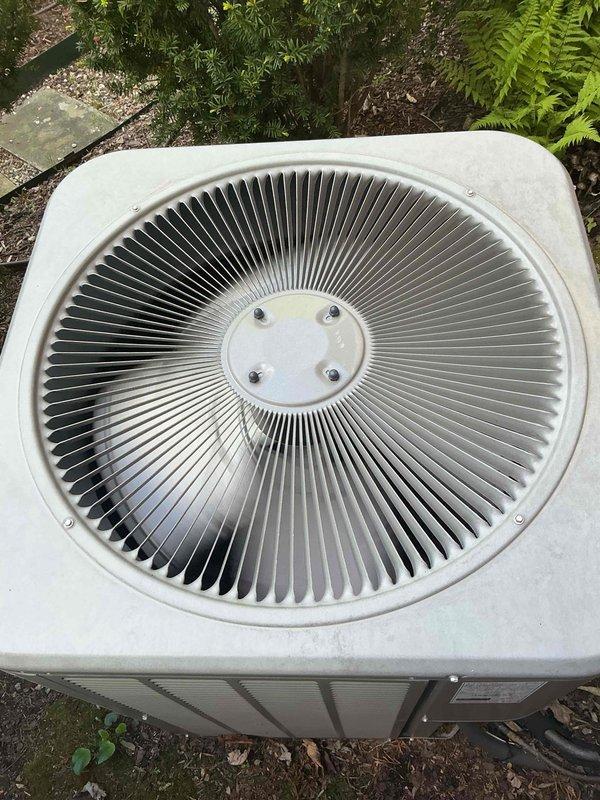 Completed comprehensive Gold AC inspection on single residential cooling system with air handler located in basement. Performed thorough examination of outdoor condenser unit, confirming proper fan assembly operation, intact coil fins, and adequate clearance from surrounding landscaping and debris. System operational with no immediate service needs identified; documented equipment condition with photographic records showing unit in functional condition with minor weathering consistent with outdoor exposure.