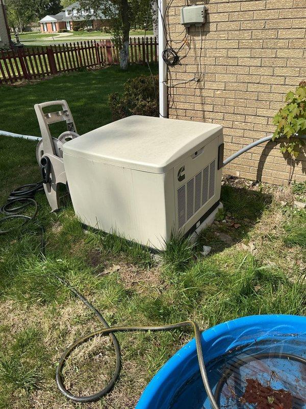 Completed preventive maintenance on Cummins standby generator unit at residential location. Performed comprehensive tune-up inspection including visual examination of electrical connections, disconnect box, and meter assembly. Verified proper operation of generator control panel and power generation system. Inspected mounting pad, ventilation grilles, and exterior housing for proper condition. All components found operational and system confirmed in working order upon completion of scheduled maintenance service.