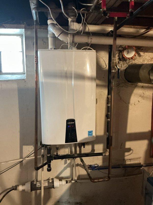 Responded to service call for tankless water heater displaying error code and failing to supply hot water throughout residence. Upon arrival, conducted diagnostic assessment of wall-mounted Energy Star certified unit in basement mechanical room. Inspected all water supply connections, gas lines, and electrical components. Tested system pressure and flow rates using calibration equipment to identify performance issues affecting hot water delivery. Examined PVC venting system, copper supply lines, and isolation valves for proper operation. Cleared error code from control panel and verified all connections at brass fittings and PEX distribution lines. Confirmed proper function of unit after troubleshooting, restoring hot water service to all fixtures throughout the home.